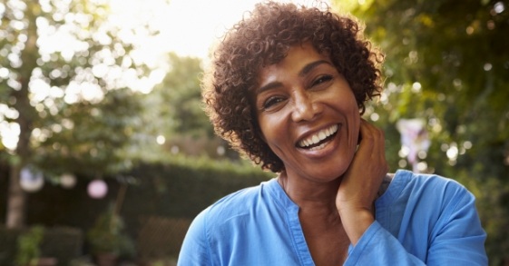 Woman in blue blouse smiling outdoors