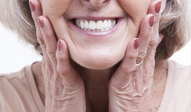 Smiling senior woman touching her face