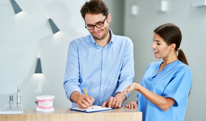 Dental team member showing a clipboard to a patient