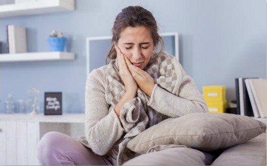 woman holding mouth in pain in Family Dental Center of East Texas   