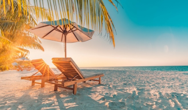 Two empty chairs under umbrella on the beach