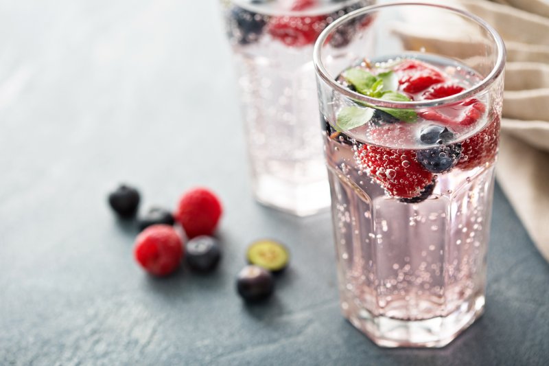 Glass of sparkling water with raspberries and blueberries