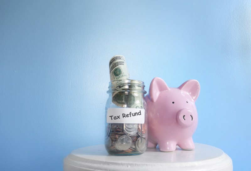 Jar labeled 'tax refund' next to piggy bank