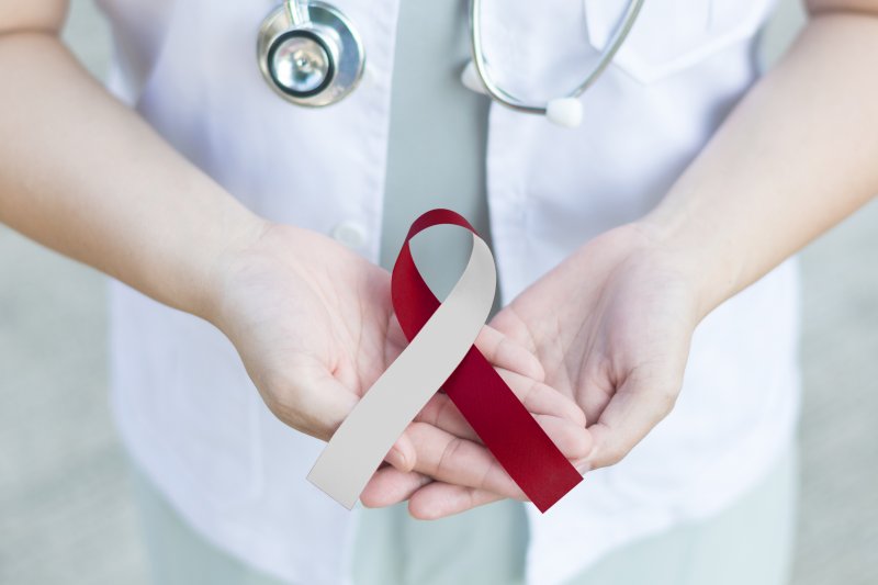 doctor holding an oral cancer ribbon