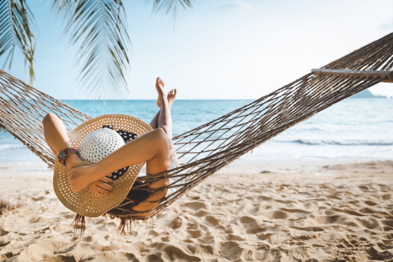 A woman relaxing in a hammock on the beach