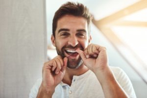 a man flossing his teeth