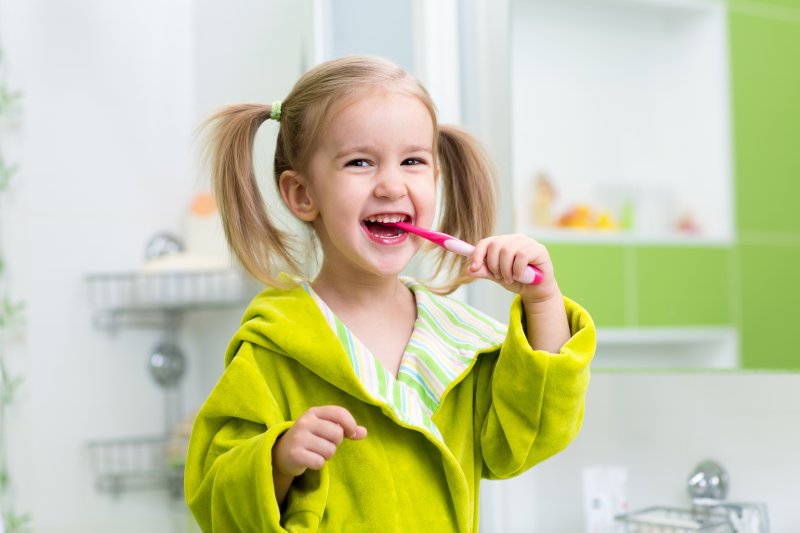 young girl smiling brushing teeth