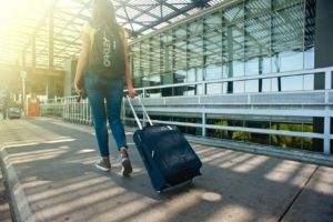 Woman with luggage walking through airport 